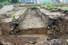 Schnitt durch den freigelegten Mühlgraben bis zur ursprünglichen Sohle, Blick flussaufwärts zu H.-Lindner Straße, deutlich ist das über Jahrhunderte durch Materialeinwurf oder Einschwemmung gestiegene Niveau zu erkennen